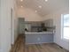 Open kitchen with grey cabinets, stainless appliances, backsplash and hardwood flooring at 4230 Kingsley Dr, Indianapolis, IN 46205