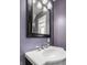 Bright bathroom boasts a decorative mirror and modern fixtures against light purple walls at 4247 Central Ave, Indianapolis, IN 46205