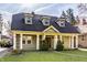 Charming exterior featuring well-manicured lawn and covered front porch at 4247 Central Ave, Indianapolis, IN 46205