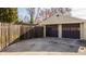 Detached garage with two brown doors and adjacent wooden fence at 4247 Central Ave, Indianapolis, IN 46205