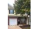 Two-story townhome featuring a brick facade, attached garage, and well-maintained landscaping in a desirable neighborhood at 4932 Tuscany Ln, Indianapolis, IN 46254
