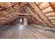 Spacious unfinished attic with exposed insulation, beams, and hardwood flooring at 5074 E Walnut St, Indianapolis, IN 46201