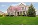 Beautiful stone-and-siding two-story home with lush lawn, flowering tree, and mature evergreens at 5196 E County Road 100 S, Avon, IN 46123