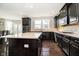 Spacious kitchen featuring an island, dark wood cabinetry, granite countertops, and hardwood floors at 5196 E County Road 100 S, Avon, IN 46123