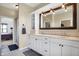 Bathroom featuring double sinks, white cabinets, a large mirror, and hexagon tile floors at 5299 W Pr Black Hawk, Edinburgh, IN 46124