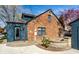 View of the brick and siding house exterior with backyard brick pavers, firepit, manicured plantings and blue skies at 5331 N New Jersey St, Indianapolis, IN 46220