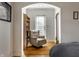 Bright bedroom featuring an arched entryway, a cozy armchair with a bookshelf, and hardwood floors at 5331 N New Jersey St, Indianapolis, IN 46220