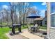 Backyard patio with BBQ grill, table and chairs, and an umbrella for shade at 5549 Dill Ct, Indianapolis, IN 46237