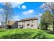 Spacious backyard with a well-manicured lawn, mature trees, and a patio area with outdoor furniture at 5549 Dill Ct, Indianapolis, IN 46237
