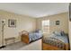 Comfortable bedroom featuring neutral walls, two twin beds with stylish gray and white bedding, and a window for natural light at 5549 Dill Ct, Indianapolis, IN 46237