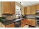 Well-equipped kitchen boasting granite counters, wood cabinetry, stainless appliances, and ample counter space, ideal for meal preparation at 5549 Dill Ct, Indianapolis, IN 46237