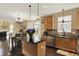 Open concept kitchen with granite countertops, wood cabinets, and a kitchen island, seamlessly flowing into the dining area at 5549 Dill Ct, Indianapolis, IN 46237