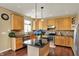 Bright kitchen featuring granite counters, wood cabinets, stainless appliances, and a center island, designed for both cooking and socializing at 5549 Dill Ct, Indianapolis, IN 46237