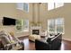 Bright living room with vaulted ceiling, fireplace, hardwood floors, and large windows at 5549 Dill Ct, Indianapolis, IN 46237