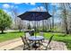 Charming patio with a round table, four chairs, umbrella, and grill, perfect for outdoor entertaining at 5549 Dill Ct, Indianapolis, IN 46237
