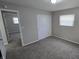 This bedroom features a closet, a window, and doorway to another room, and has neutral walls and flooring at 5636 W Henry St, Indianapolis, IN 46241