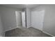 This bedroom has neutral walls and carpet flooring, and includes a closet and doorway to another room at 5636 W Henry St, Indianapolis, IN 46241