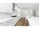Modern kitchen with white cabinets, stainless steel vent hood, and large island sink at 5661 Stetson Dr, Whitestown, IN 46052
