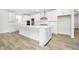 Spacious kitchen with a large island, white cabinets, modern stainless appliances, and wood flooring at 5661 Stetson Dr, Whitestown, IN 46052