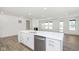 Open-concept kitchen island with stainless steel dishwasher flows into the living room at 5661 Stetson Dr, Whitestown, IN 46052
