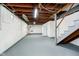 Spacious unfinished basement featuring exposed wood beams and painted walls and floor at 5715 N Meridian St, Indianapolis, IN 46208