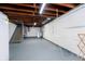 Unfinished basement with exposed wood ceiling, laundry area, and painted concrete floor at 5715 N Meridian St, Indianapolis, IN 46208