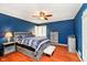 Comfortable bedroom with a large bed, blue walls, wood floors, and contemporary furnishings offers a relaxing retreat at 5715 N Meridian St, Indianapolis, IN 46208