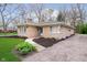 Charming stone home with driveway, manicured lawn, and landscaping at 5715 N Meridian St, Indianapolis, IN 46208