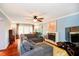 Bright living room with hardwood floors, gray sectional sofa, and blue walls at 5715 N Meridian St, Indianapolis, IN 46208