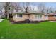A view of the rear of the house with green lawn and mature trees at 5715 N Meridian St, Indianapolis, IN 46208