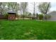 Spacious backyard featuring mature trees, a wooden playhouse, and a well-maintained lawn for outdoor enjoyment at 601 E 95Th St, Indianapolis, IN 46240