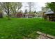 Expansive backyard with lush lawn, an outdoor playhouse, and mature trees perfect for playing and relaxing at 601 E 95Th St, Indianapolis, IN 46240