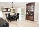 Open dining area featuring an elegant light fixture, sliding door access to the backyard, and hardwood floors at 601 E 95Th St, Indianapolis, IN 46240