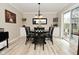 Bright dining area featuring an elegant light fixture, sliding door access to the backyard, and hardwood floors at 601 E 95Th St, Indianapolis, IN 46240