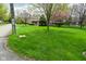 Well-manicured front yard with lush green lawn and mature trees, showcasing the home's curb appeal at 601 E 95Th St, Indianapolis, IN 46240
