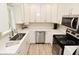 Modern kitchen with stainless steel appliances, white cabinets and countertops, plus a stainless steel sink at 601 E 95Th St, Indianapolis, IN 46240