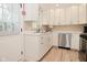 Bright open kitchen with stainless steel appliances and white cabinets, door to backyard at 601 E 95Th St, Indianapolis, IN 46240