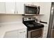 Updated kitchen features stainless steel microwave, black oven with white cabinets and countertops at 601 E 95Th St, Indianapolis, IN 46240