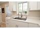 Modern kitchen featuring white countertops and cabinets, stainless steel faucet and fixtures, and a window overlooking the outdoors at 601 E 95Th St, Indianapolis, IN 46240