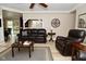 Open living room featuring stylish leather seating, a ceiling fan, new light flooring and views to other rooms at 601 E 95Th St, Indianapolis, IN 46240