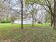 Spacious backyard featuring a white shed, mature trees, and lush greenery, ideal for outdoor activities at 6113 N 250 E, Greenfield, IN 46140