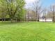 Lush green backyard, dotted with trees and a white shed, offering a serene and spacious outdoor setting at 6113 N 250 E, Greenfield, IN 46140