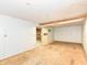 Unfinished basement with painted walls and plywood flooring, with access to storage room at 6113 N 250 E, Greenfield, IN 46140