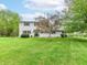 Well-maintained two-story home with a large, lush front yard and mature trees at 6113 N 250 E, Greenfield, IN 46140
