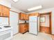 Functional kitchen featuring white appliances, wooden cabinets, and easy access to dining area at 6113 N 250 E, Greenfield, IN 46140
