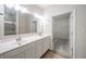 Bright bathroom featuring a double vanity, large mirror, and view of a walk-in closet, seamlessly blending functionality and style at 6204 Fairview Dr, McCordsville, IN 46055