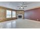 Spacious living room featuring a fireplace, a ceiling fan, and a wall with wainscoting at 6534 Redland Way, Indianapolis, IN 46217