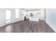 Bright, open-concept kitchen with stainless steel appliances, white cabinetry, and gray wood flooring at 6801 Seabiscuit Rd, Whitestown, IN 46075