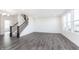 Open-concept living room with luxury vinyl plank flooring, staircase, and large windows for ample natural light at 6801 Seabiscuit Rd, Whitestown, IN 46075