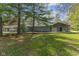 Quaint home with a well-maintained lawn and mature trees offers a serene backyard retreat at 7104 Combs Rd, Indianapolis, IN 46237